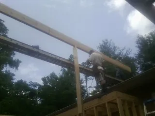 Carpenter setting a ridge beam over a new addition frame — Ice Dam Removal by Roofing Brothers in Dukedom