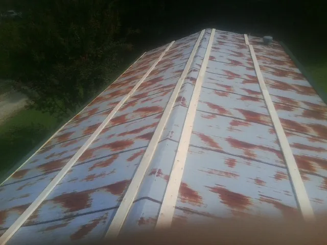 Rusted metal roof panels with new wood purlins before replacement — Storm Damage Roof Repair in Dukedom by Roofing Brothers